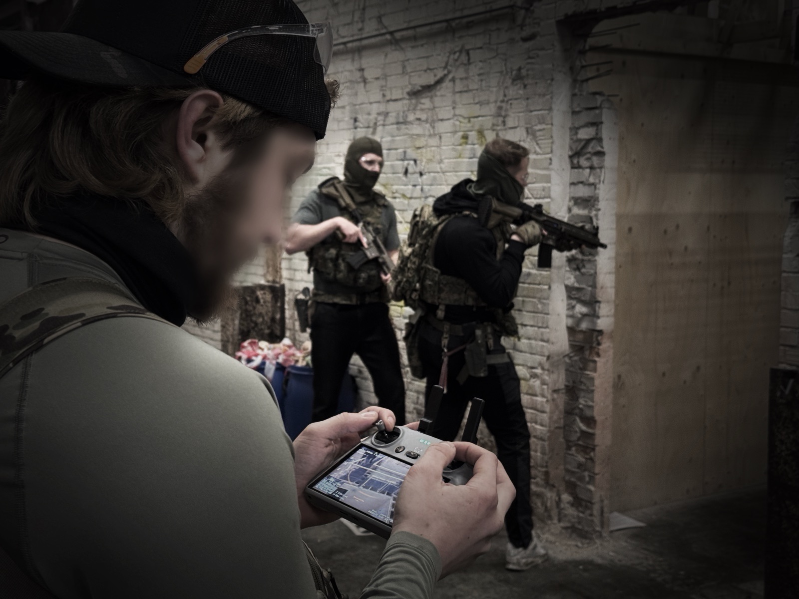 Operator met drone-controller, operators clearen op de achtergrond